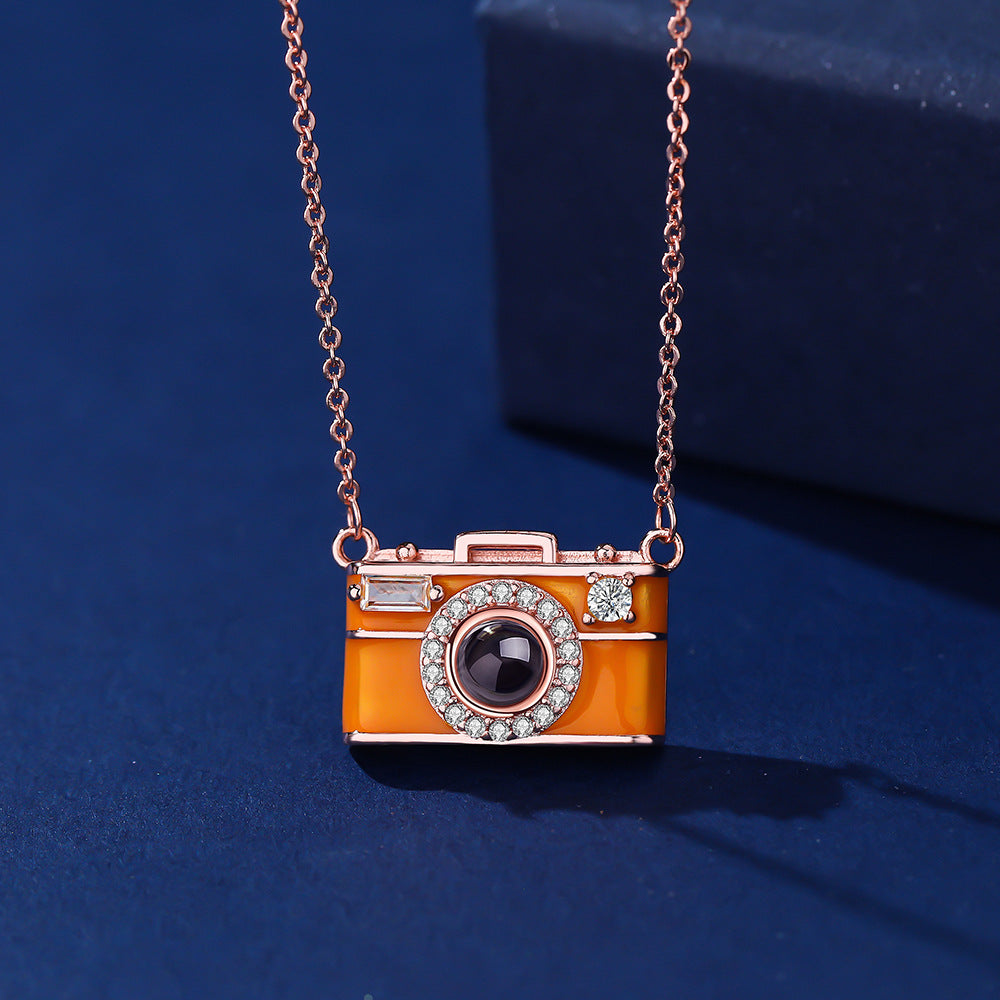 Camera-shaped pendant necklace on a blue background