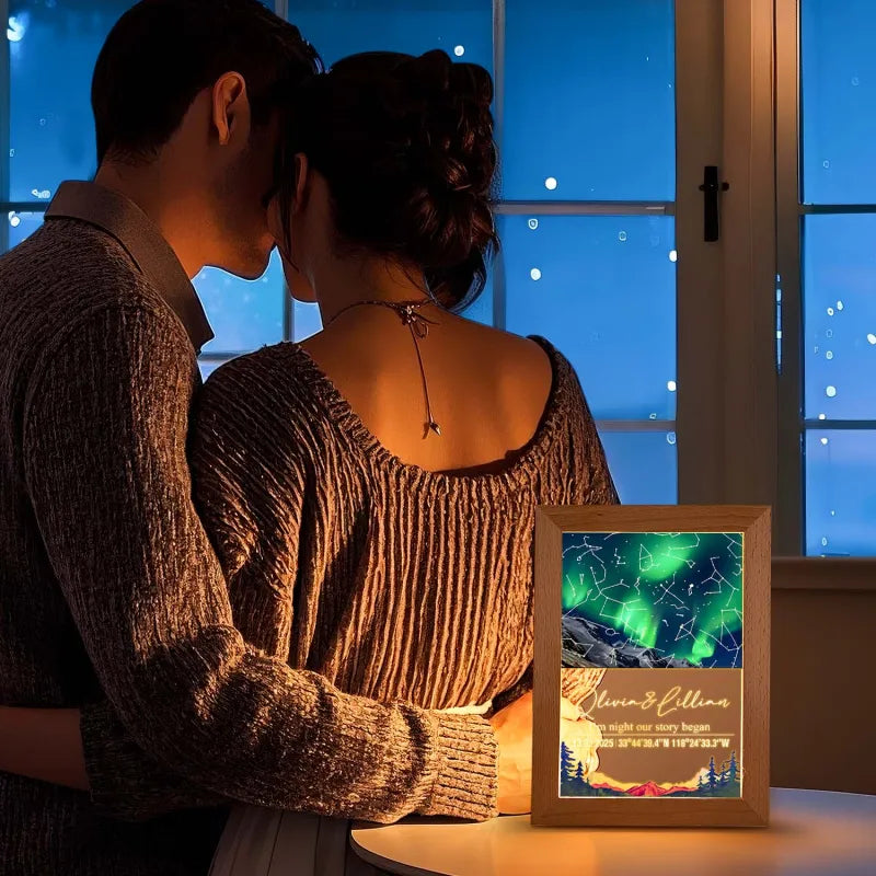 Couple embracing by a window with a framed photo of a mountain landscape and text.