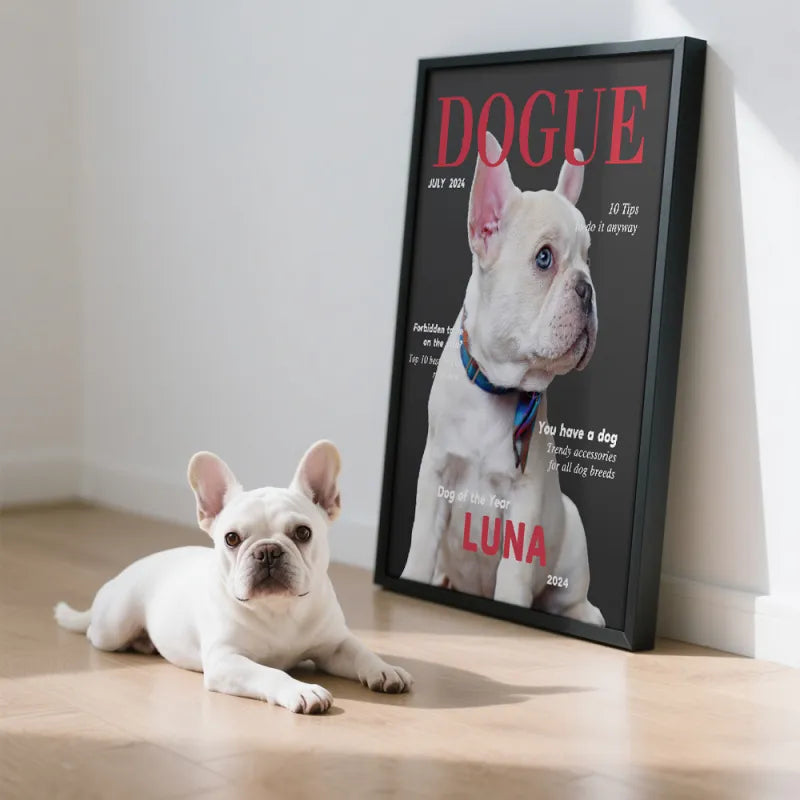 White dog lying on a wooden floor next to a framed magazine cover featuring another white dog.