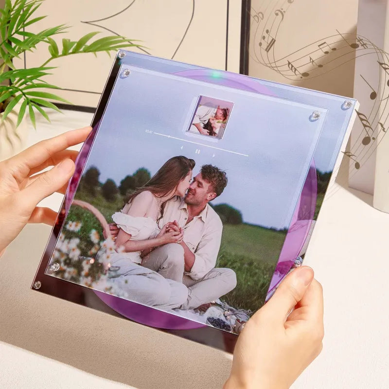Person holding a transparent photo album with a couple on a grassy field