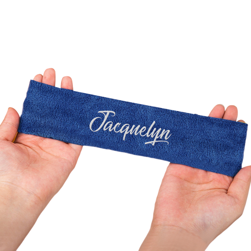 Blue headband with 'Jacquelyn' printed on it held by hands against a white background