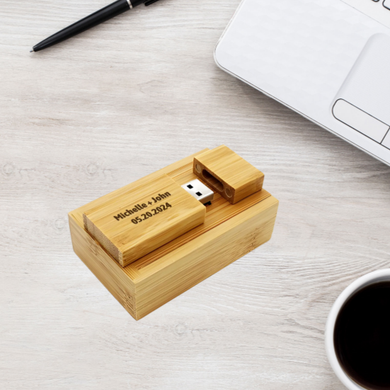 Wooden USB drive with engraved text on a light wooden surface with a pen and coffee cup.