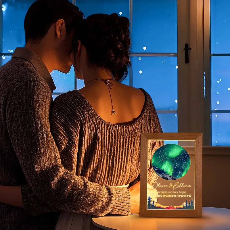 Couple embracing by a window with a framed picture of a green planet and names.