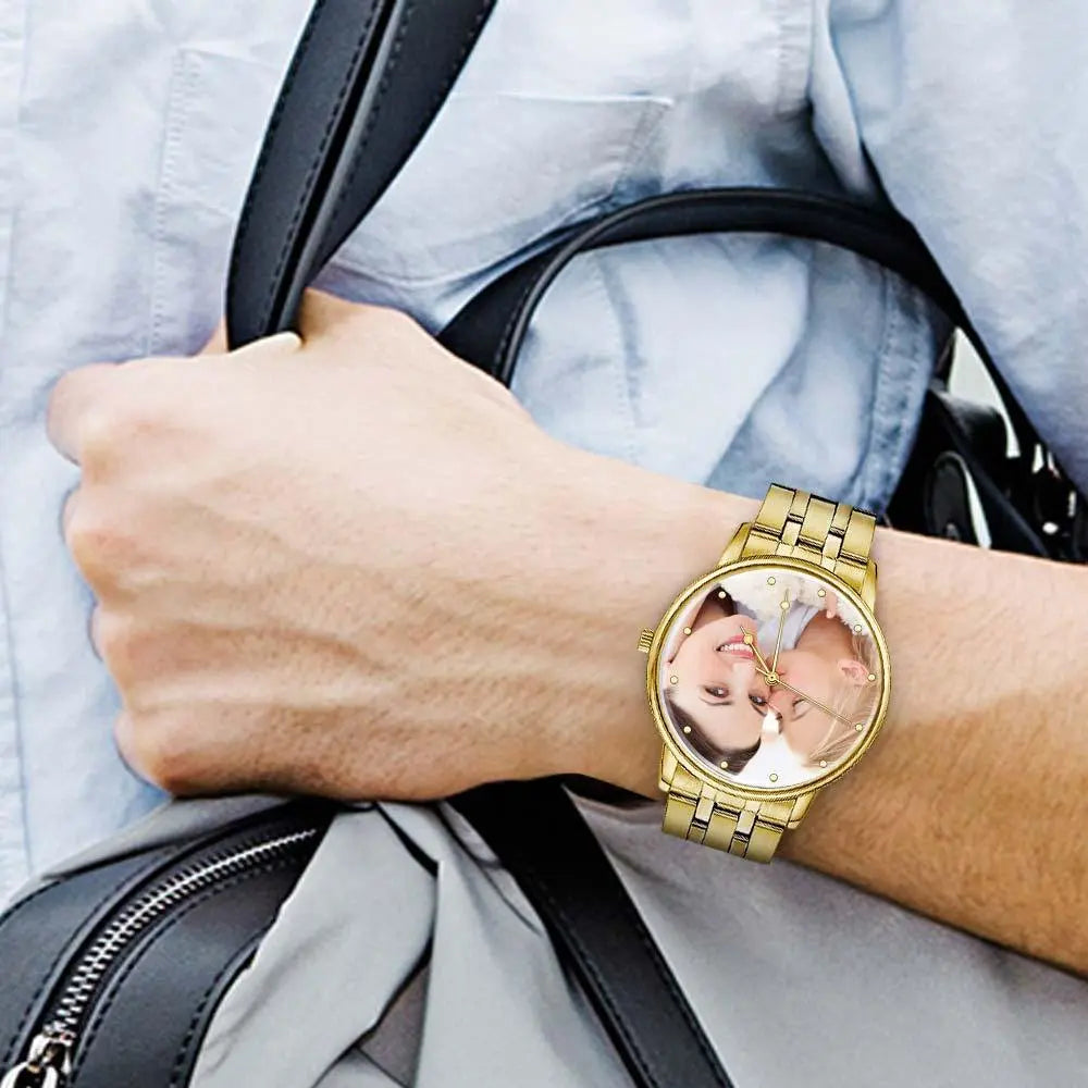 Gold watch with a reflective face on a wrist, held by a person with a black bag.