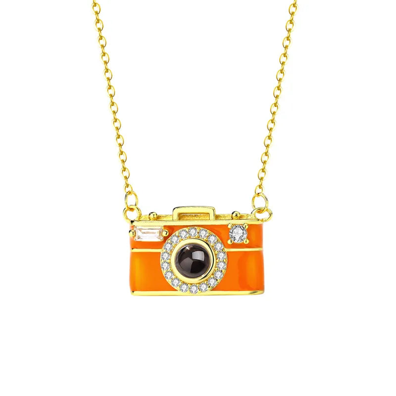 Necklace with an orange camera-shaped pendant on a white background