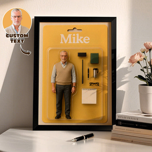 Framed action figure of a man named Mike on a yellow background with a pen and books in the foreground.