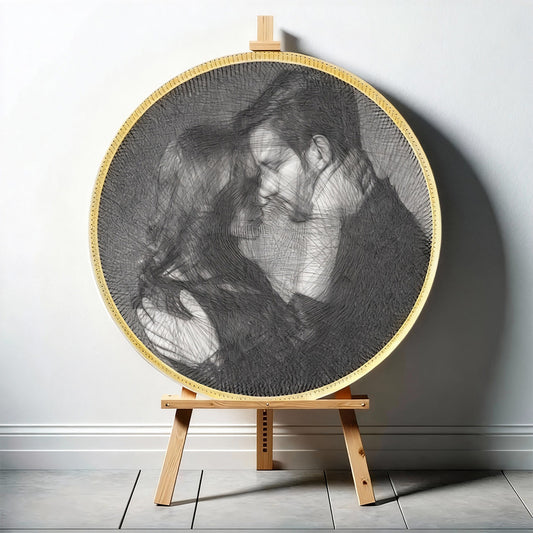 Circular string art of a woman with a man on an easel against a gray wall.