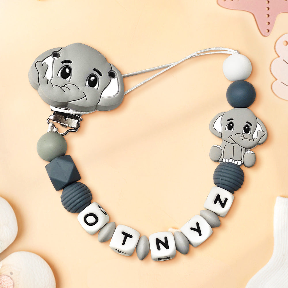 Gray elephant-shaped teether with beads and letter tiles on a beige background