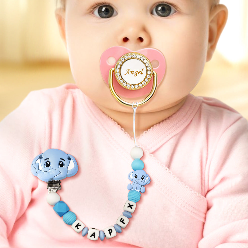 Baby with a decorative pacifier clip and pink pacifier