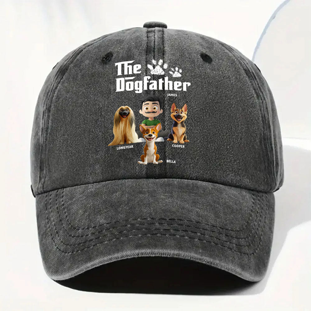 A dark gray washed baseball cap featuring a custom graphic print with the text 'The Dogfather' and cartoon illustrations of four dogs with names underneath, shown against a clean white background.