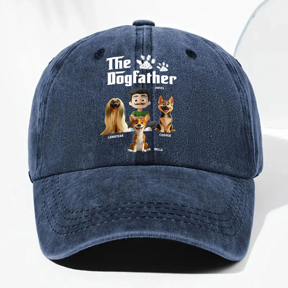 A navy blue washed baseball cap featuring a custom graphic print with the text 'The Dogfather' and cartoon illustrations of four dogs with names underneath, shown on a clean white background.