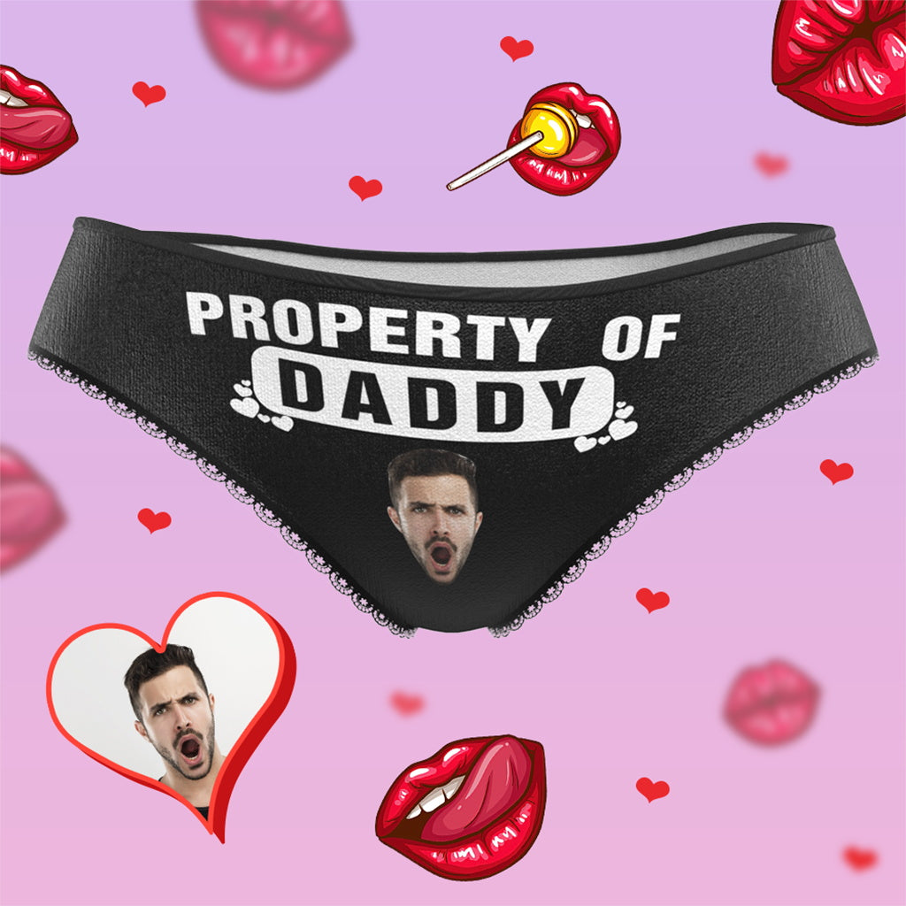 Black thong with 'PROPERTY OF DADDY' text on a pink background with hearts and lips.