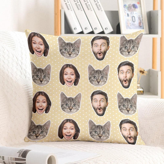 Decorative pillow with printed faces and cat faces on a couch.