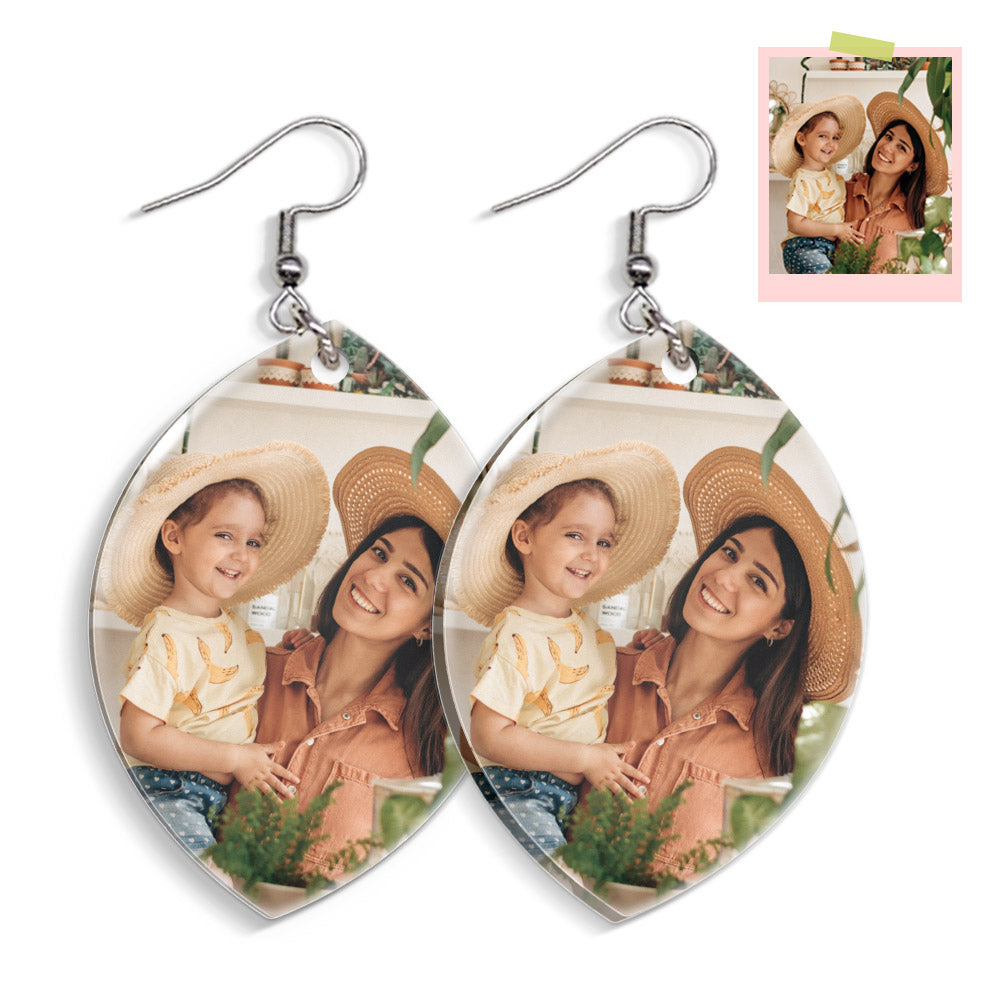 Heart-shaped photo earrings with a family picture of a woman and child wearing hats.