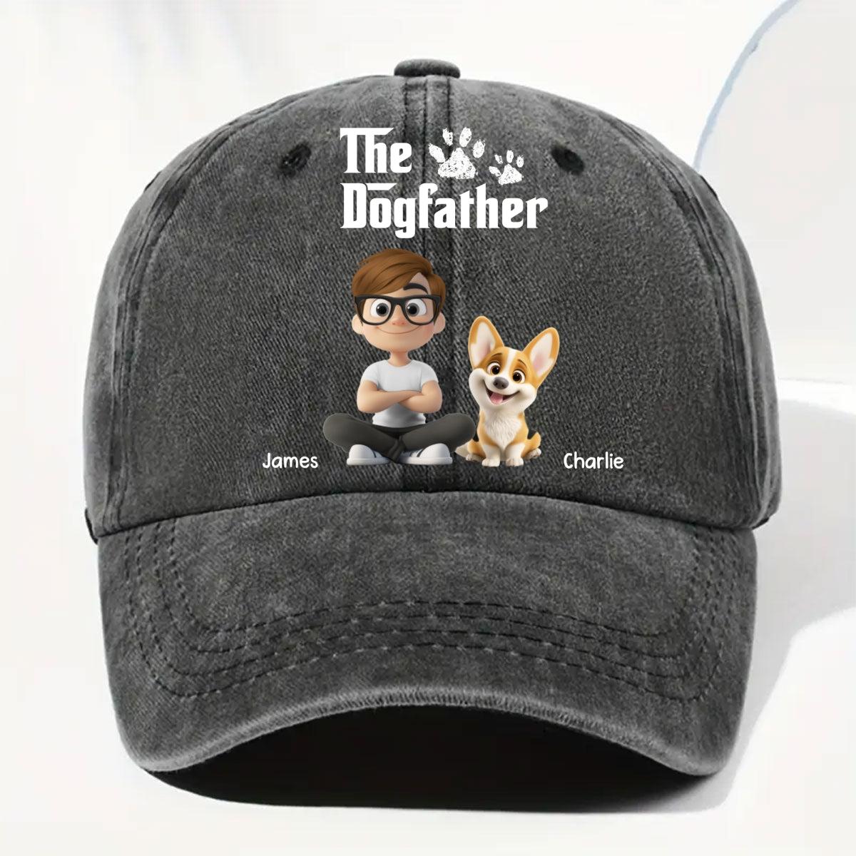 A dark gray washed baseball cap featuring a custom cartoon graphic of a man and a corgi dog with the text 'The Dogfather' and names 'James' and 'Charlie' printed on the front.