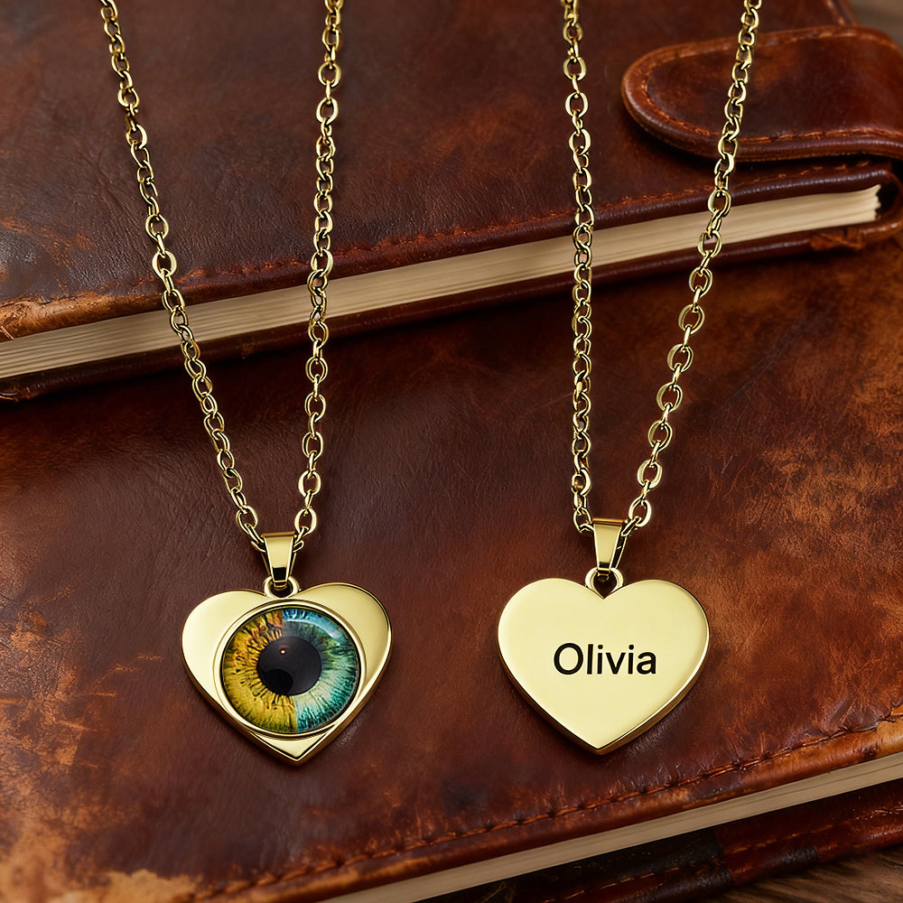 Two gold heart-shaped pendants on a leather surface