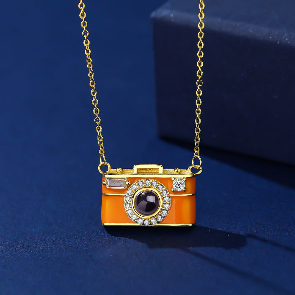 Camera-shaped pendant necklace on a blue background