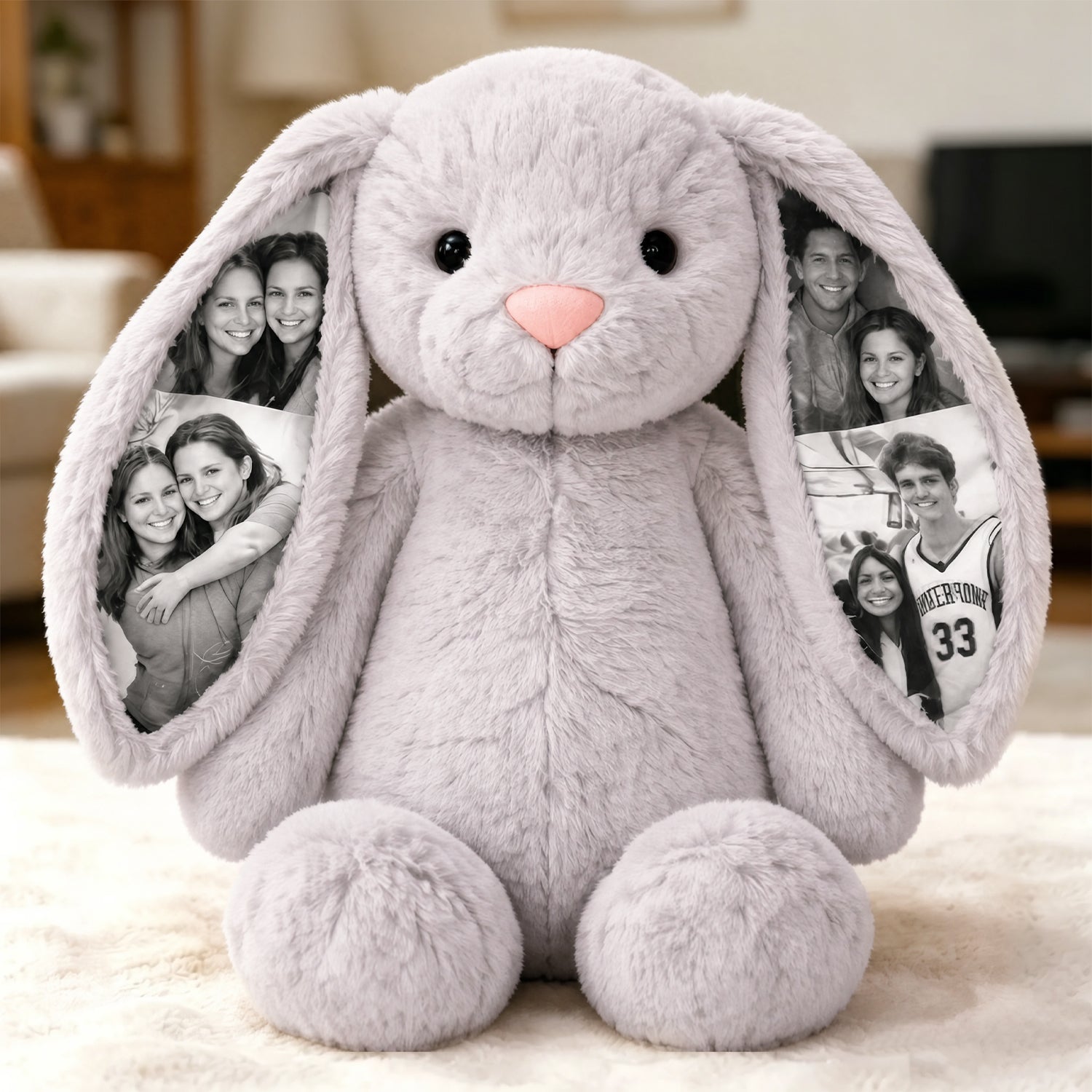 Gray plush bunny with photo frames in ears on a light background