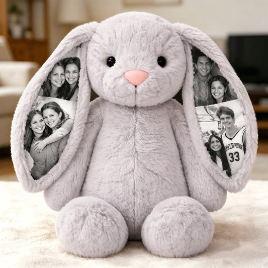 Gray plush bunny with photo frames in ears on a light background
