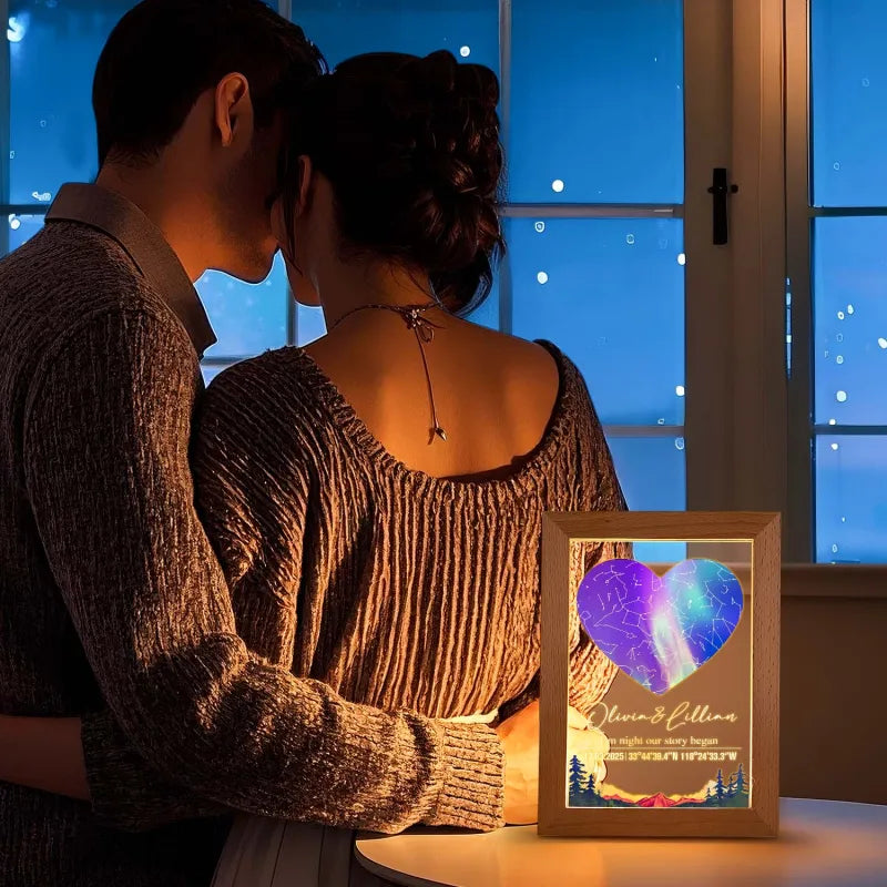 Couple embracing by a window with a personalized light box displaying a heart design.