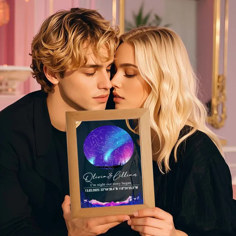 Two people holding a framed picture with a purple and blue design.