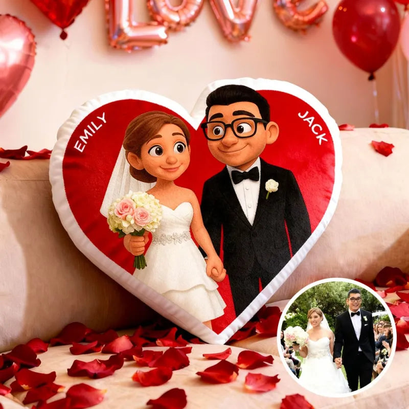Wedding-themed pillow with cartoon bride and groom, surrounded by red balloons and rose petals.